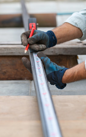 man measures metal with a ruler for cutting, hands close-upの写真素材