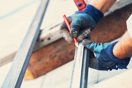 man measures metal with a ruler for cutting, hands close-upの写真素材