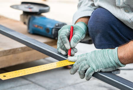 man measures metal with a ruler for cutting, hands close-upの写真素材