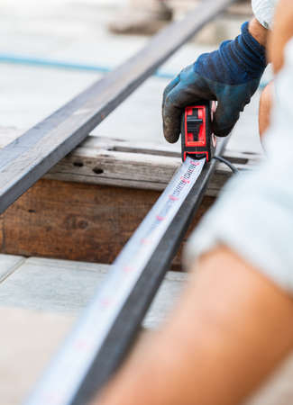 man measures metal with a ruler for cutting, hands close-upの写真素材