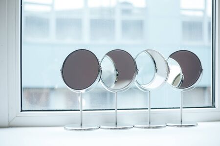 four silver makeup mirror are hardly near the windowの写真素材