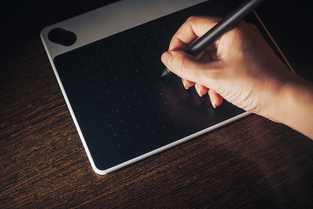 Unrecognizable woman working from home writing on graphic tabletの写真素材