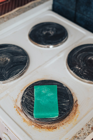 Detergent with protective gloves and sponge on electric hob closeup. For 'lectric cooker applied for washing grease and rustの写真素材