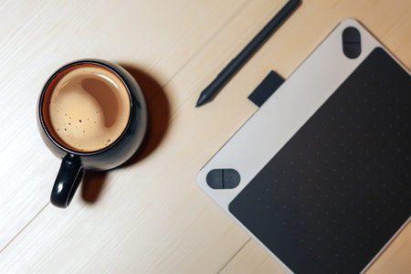 Flat lay photography of creative desk, Overhead view of graphic tablet, graphic pen, smartphone eyeglasses, keyboard and a cup of black coffee, Workspace desk of creative designerの写真素材
