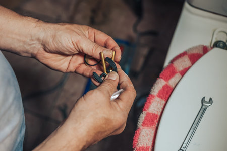 Man repair and fixing leaky old faucet in bathroomの写真素材