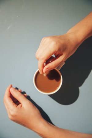 Young woman relaxing in hotel on brackfast with cup of coffee and macaroon.の写真素材