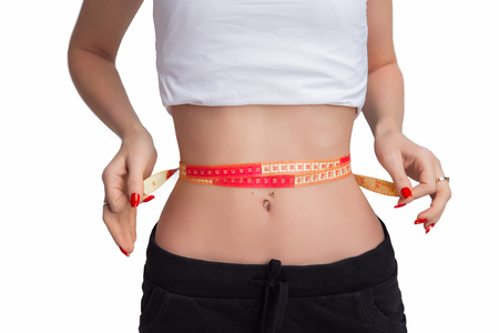 Woman measures her waistline, isolated on white backgroundの写真素材
