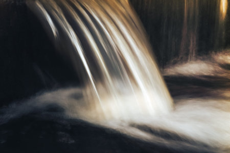 cold waterfall long exposure. Closeup view of little waterfall on the river current in the moonlight long exposure in old Petergoffの写真素材