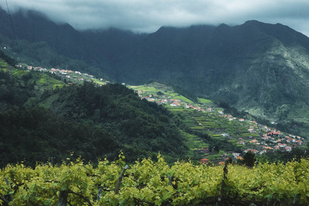Aerial view from above over small village in the mountains. Foggy weather, dark pictureの写真素材