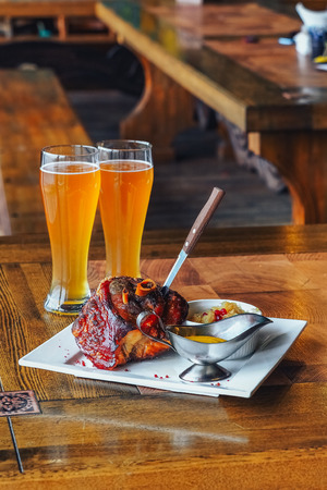 Traditional Czech pork knuckel on the bone speared with a knifeの写真素材