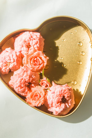 Orange roses in a heart-shaped metal box.の写真素材