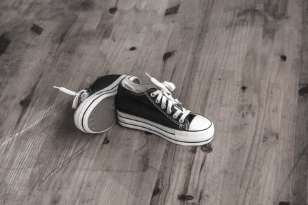 Black sneakers on the wooden floor.の写真素材