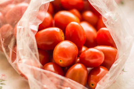 A number of small red tomatoes on the floor.の写真素材
