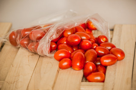 Tomato red bag is placed on a wooden floor.の写真素材