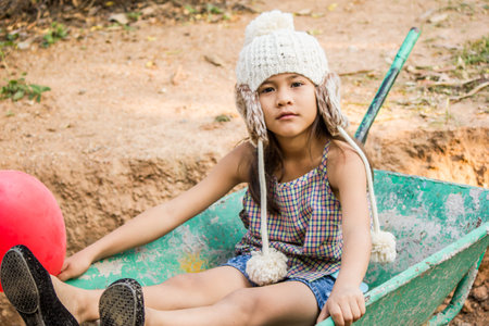 A young girl sitting on a sand cart