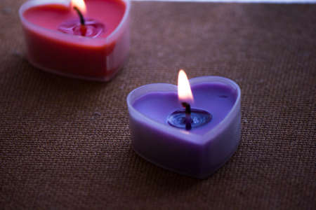 Two heart-shaped candles were lit, giving off a fragrant scent.の写真素材
