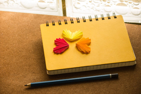 Colorful paper hearts are placed on the notebook.