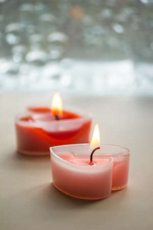 Two heart-shaped candles were lit, giving off a fragrant scent.の写真素材