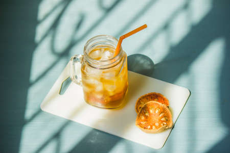 Aegle marmelos, an ice-cold herbal drink with health benefits in a glass with ready-to-drink straws placed by the window where sunlight enters the room.の写真素材