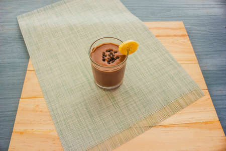 Chocolate Banana Shake Topping Sprinkled with Chocolate Chips, Banana and Mint Leaves with Straw on Clothの写真素材