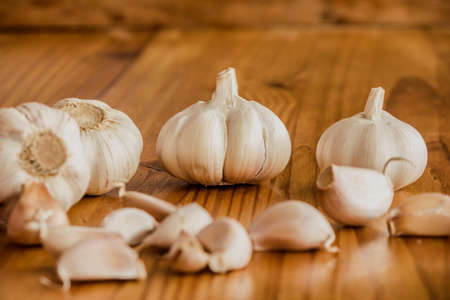 Garlic is a culinary and medicinal plant on a wooden backgroundの写真素材