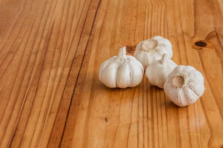 Garlic is a culinary and medicinal plant on a wooden backgroundの写真素材