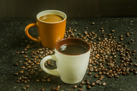 Two cups of coffee. Two flavors on black background. Top view.の写真素材