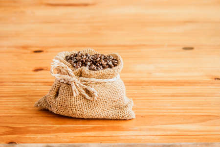 A bag of coffee beans on an old wooden floorの写真素材