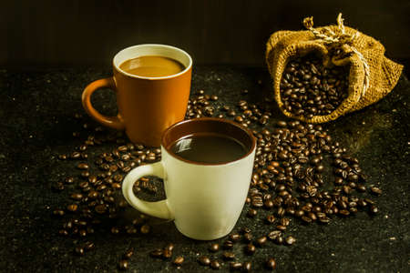 Two cups of coffee. Two flavors on black background. Top view.の写真素材