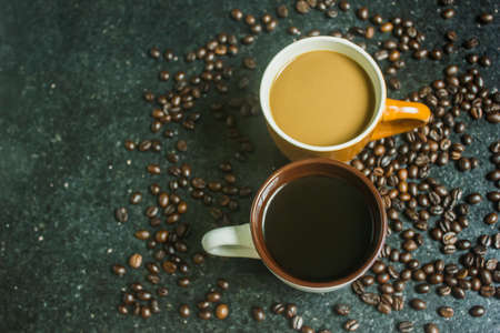 Two cups of coffee. Two flavors on black background. Top view.の写真素材