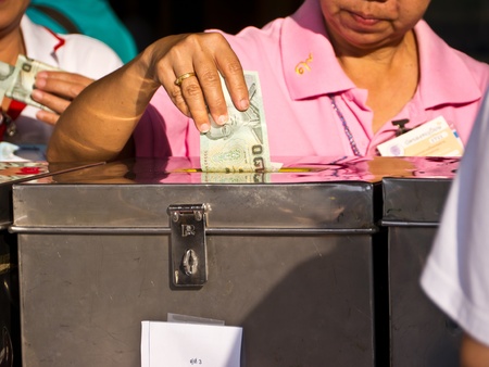 Woman put money into donation boxの写真素材