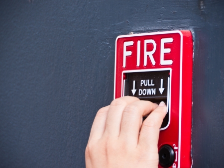 Hand on fire alarm boxの写真素材