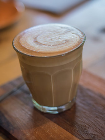 Cup of hot coffee on wooden board