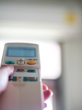 Hand on remote control to air conditionerの写真素材