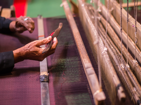 Thai artist is weaving handicraft cloth with local apparatusの写真素材