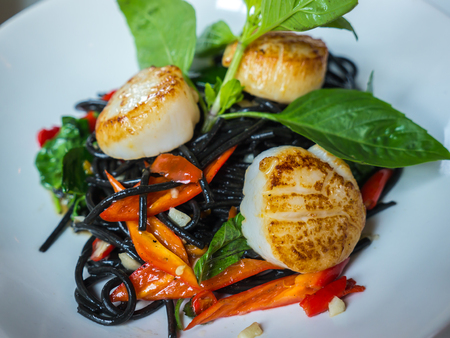 Stir-fried black spaghetti scallop with chili sauce and herbの写真素材