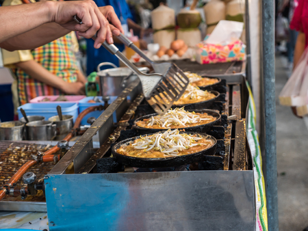 Street food, eggs stir-fried with bean sprouts on pan, in Thai local marketの写真素材