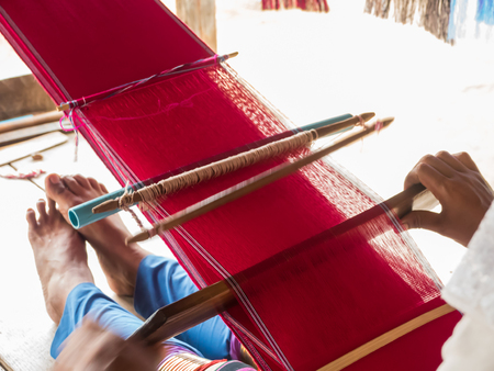Tribe woman is weaving handicraft clothの写真素材
