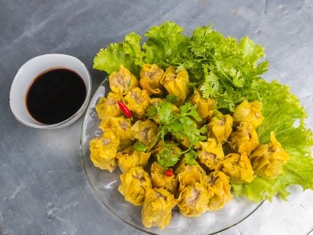 Pork dumpling and vegetable with soy sauce on plateの写真素材