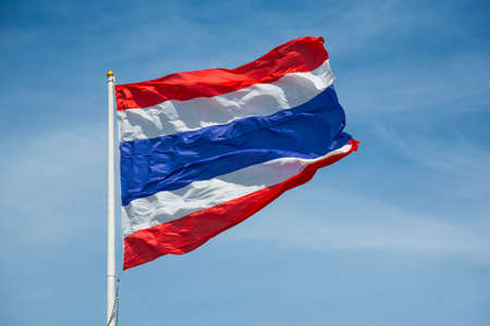 Waving Thai flag of Thailand with blue sky backgroundの写真素材