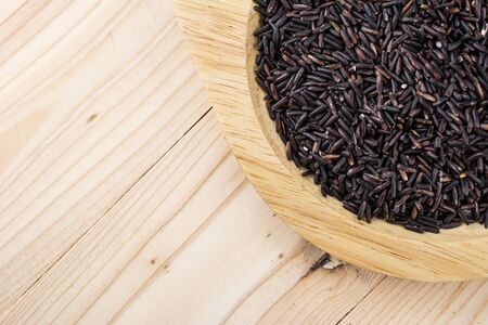 Close-up brown rice or riceberry organic food in bowl healthy on wood textureの写真素材