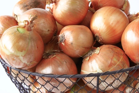 many big onions in a decoratively wire basketの写真素材