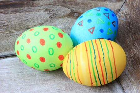 colorful Easter eggs on an old, gray wooden board