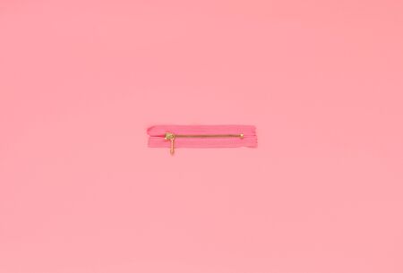 Pink zipper on a pink background. Flat lay concept, top view.の写真素材