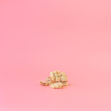Crushed honey cake on a pink background.