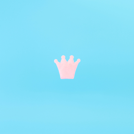 Pink crown on a blue background. Minimal concept photo. Avatar.の写真素材