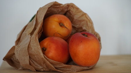 Apricot in a paper bag there is 3 of themの写真素材