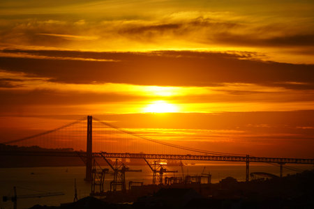 Silhouettes enjoying the sunset hour in Lisbon by the water.