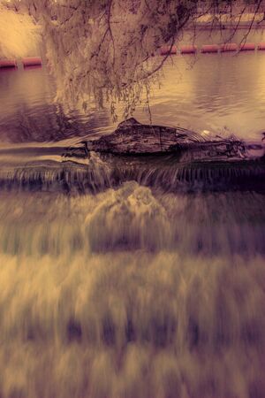 Infrared river photography - Log in the weir photo taken in Bedford UKの写真素材