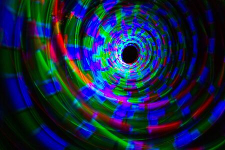 Abstract light painting taken while spinning bright coloured glowing poi in a spiral の写真素材